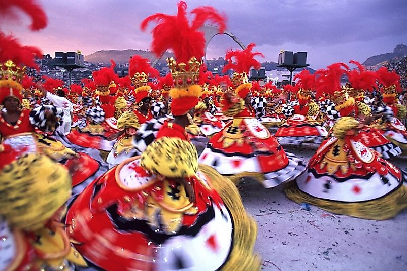 Women dance in the streets of Rio de Janeiro wearing colorful costumes during Carnival.