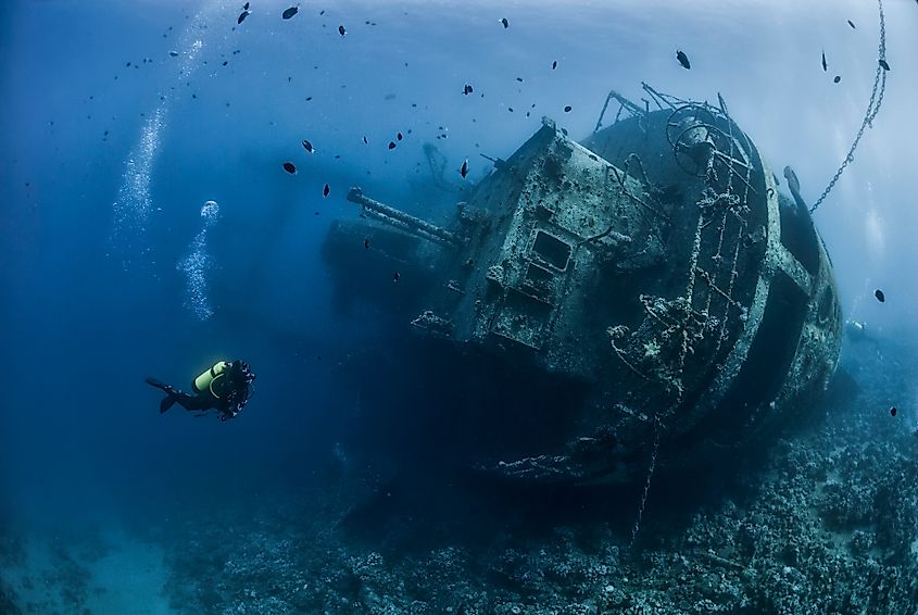 Divers exploring an underwater shipwreck.