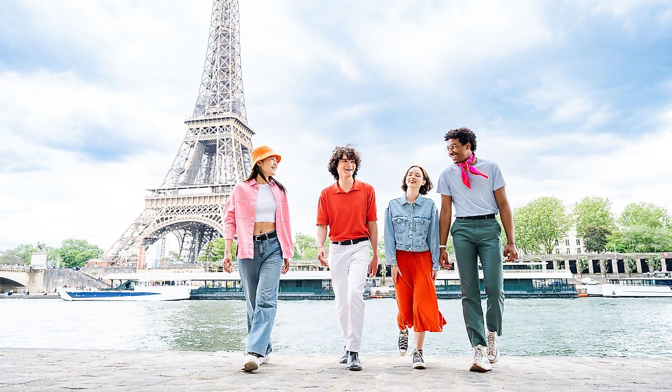 Group of happy friends visiting the Eiffel Tower in Paris, France. Image Credit oneinchpunch via Shutterstock.