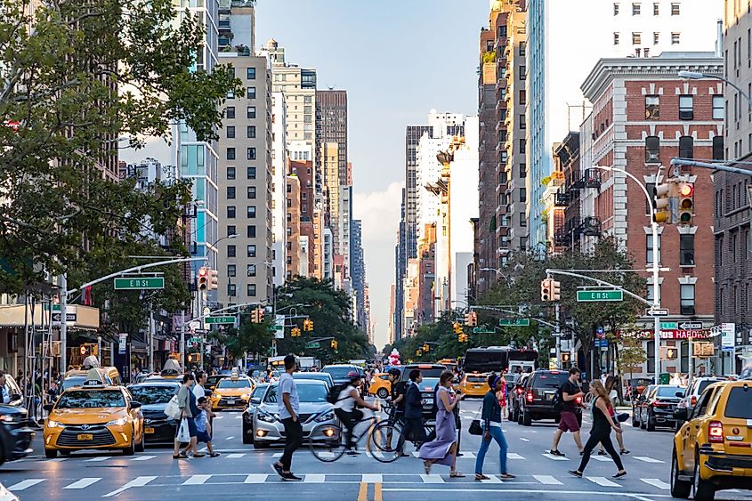 Busy crowds of people walk across 3rd Avenue in front of rush hour traffic in the East Village neighborhood of Manhattan in New York City. Editorial credit: Ryan DeBerardinis / Shutterstock.com